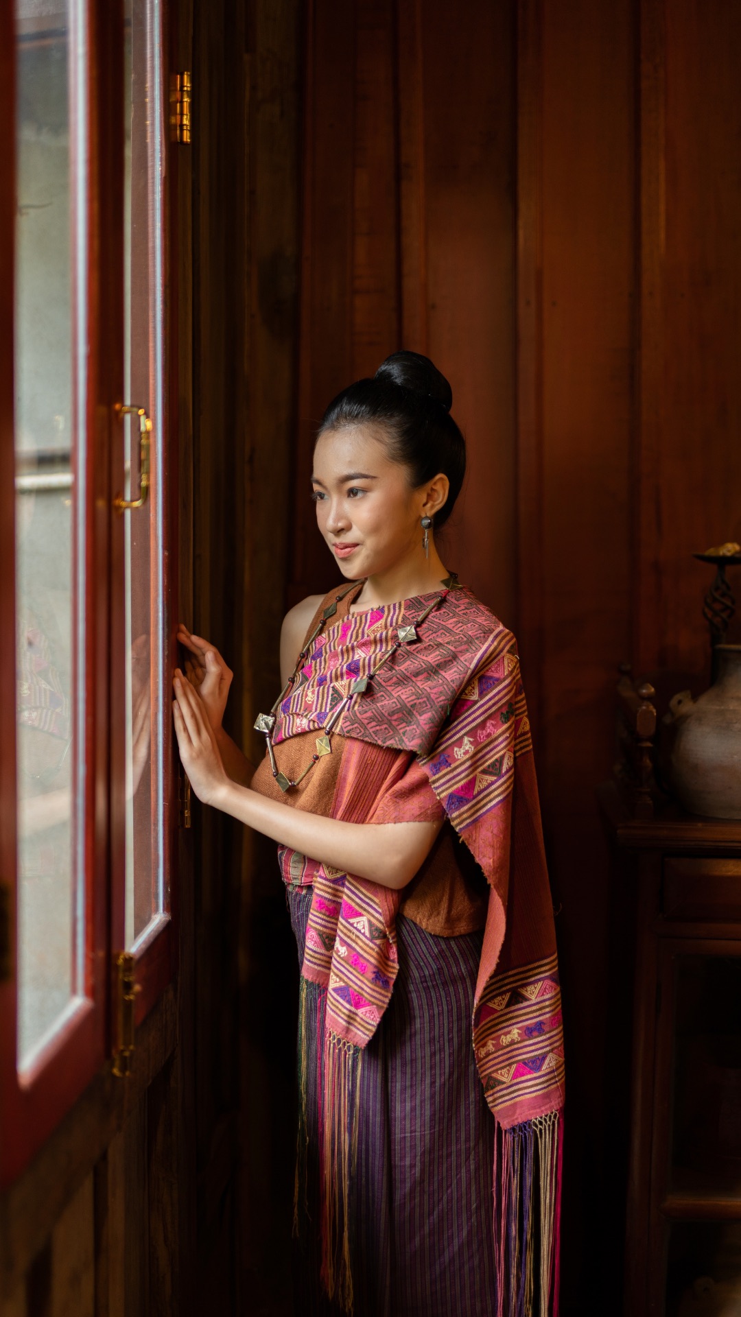 Jeune femme en tenue traditionnelle laotienne, tissage et bijoux artisanaux