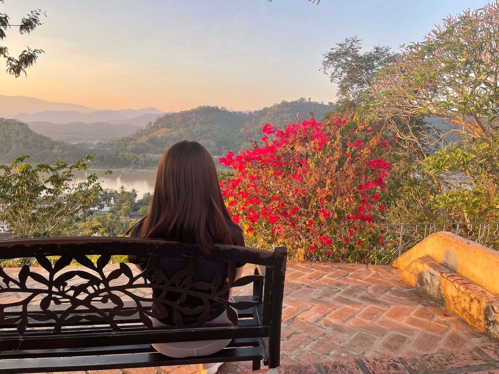 Margaux lisant sur une terrasse au bord du Mékong, au coucher du soleil