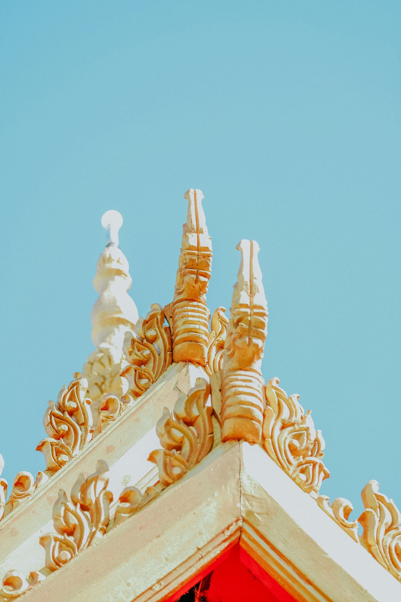 Temple ancien aux toits superposés, sculptures dorées dans la lumière du soir
